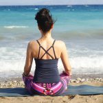 Eine Frau, die am Strand meditiert